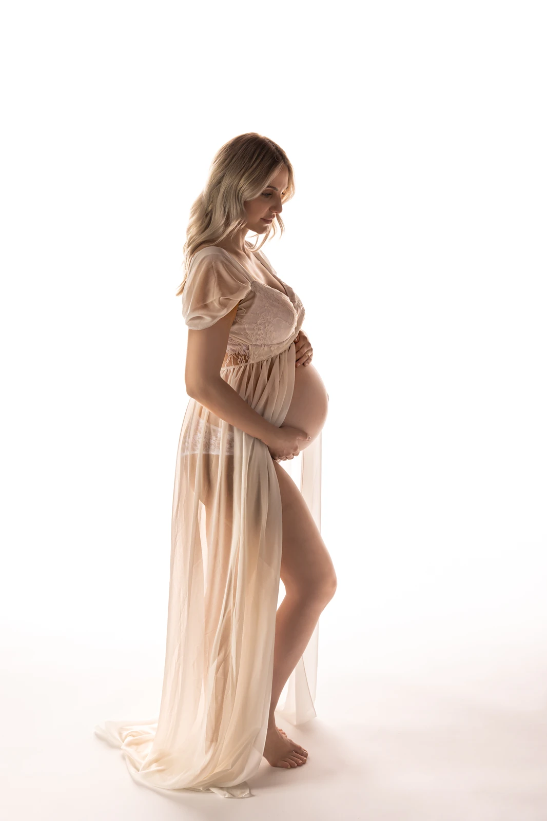 Schwangerschaftsfoto- schwangere umfasst ihren Bauch- verträumtes Bild