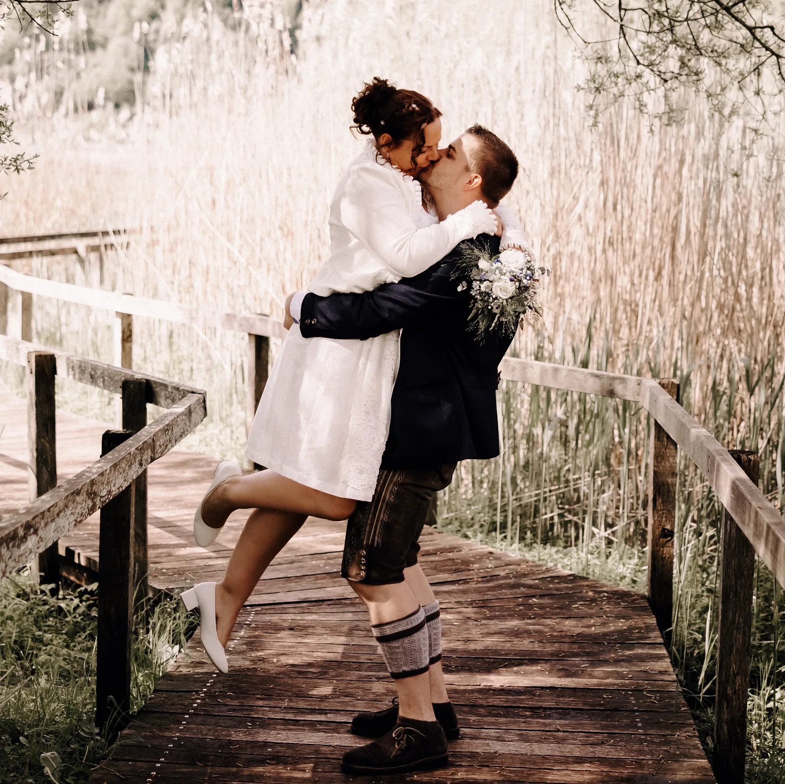 Hochzeitsfotograf Luzern-Zentralschweiz-Bräutigam hebt Braut hoch und küsst sie