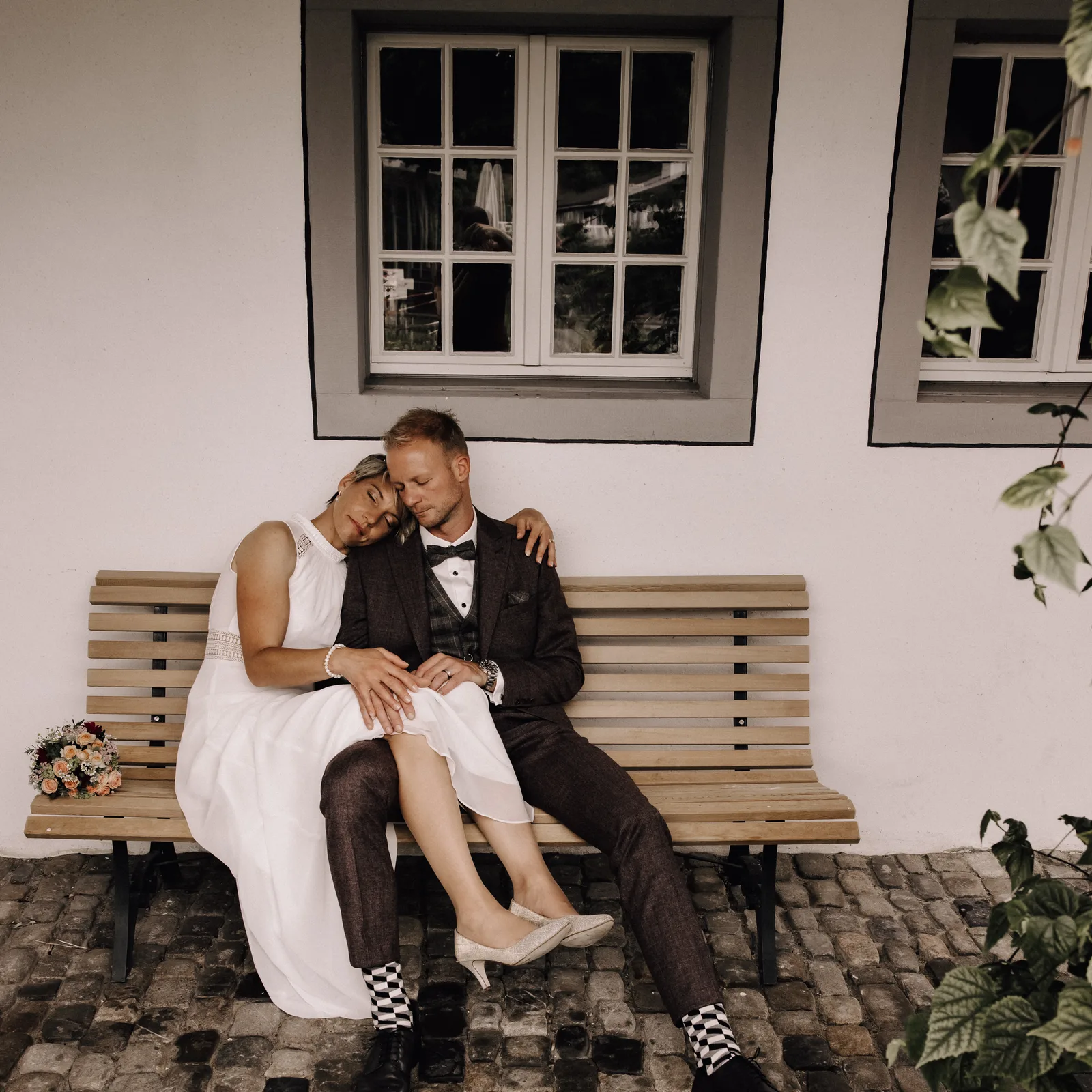 Hochzeitsfotograf Schweiz Luzern-Brautpaar sitzt verträumt auf Bank-Boho style